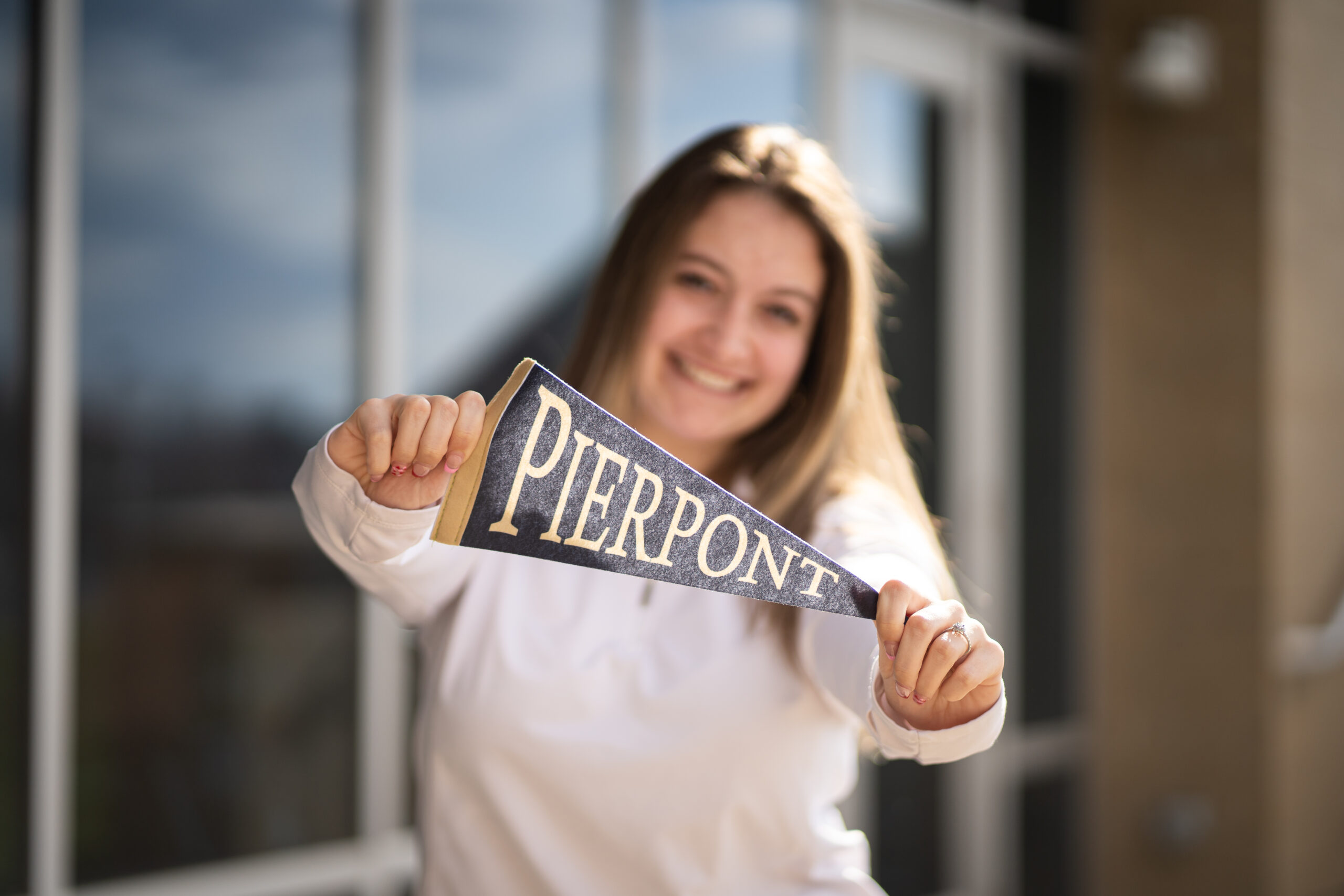 A student is pictured holding a Pierpont pennant.