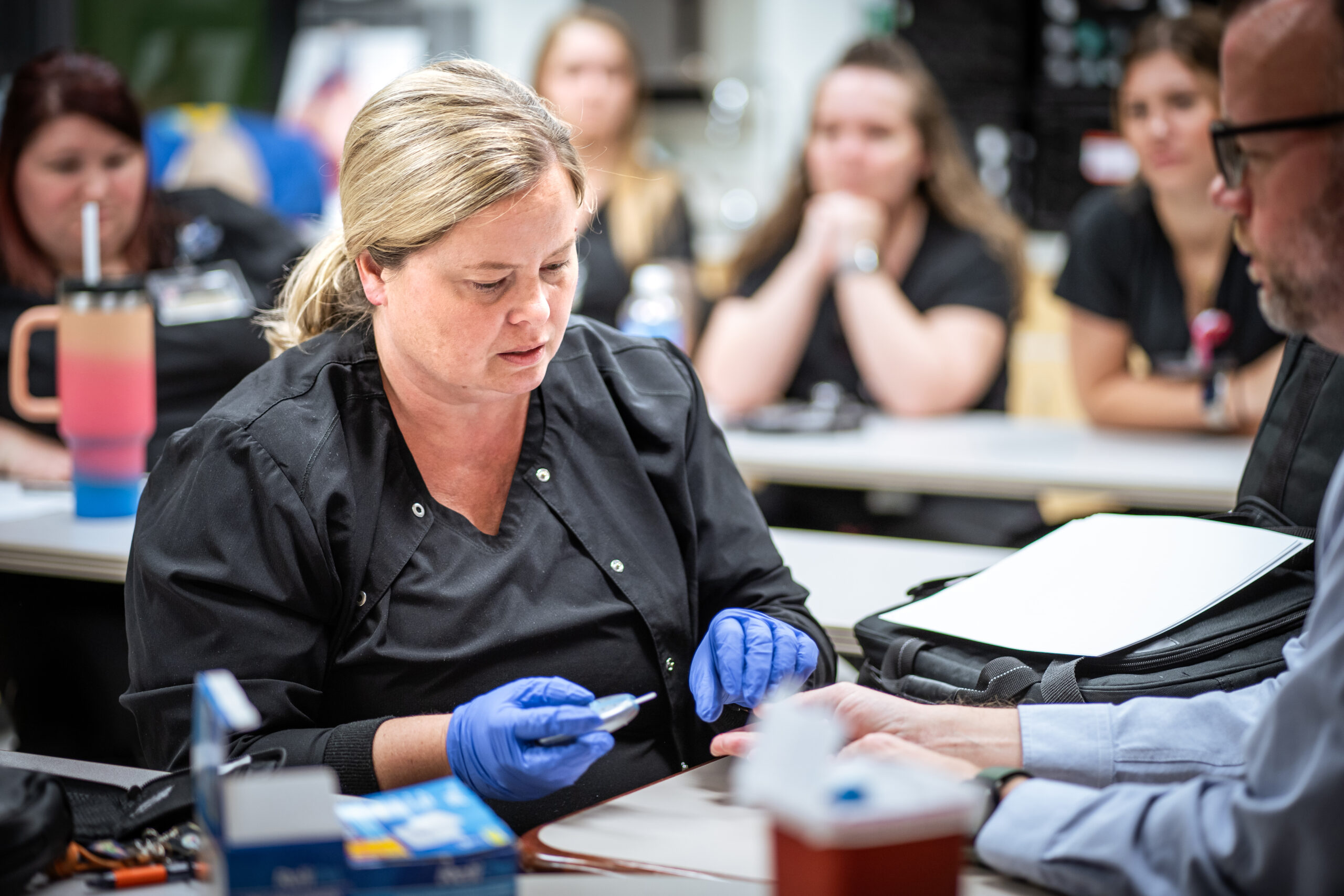 A nursing student prepares to complete a glucose finger test.