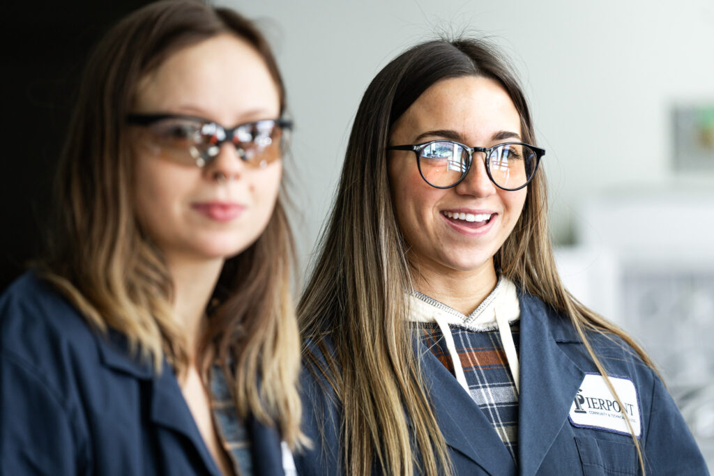 Two students are featured smiling.