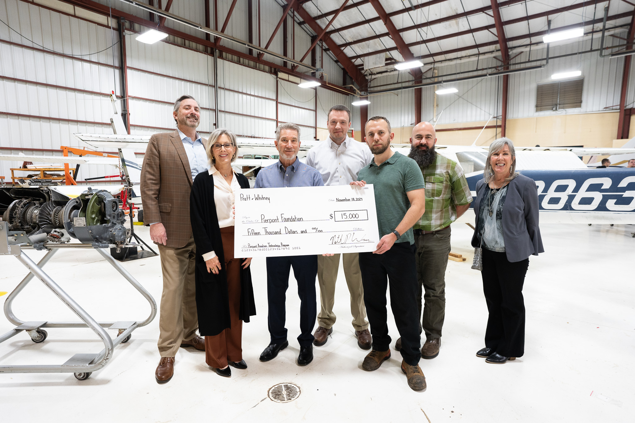 The group poses for a photo with the donation check.